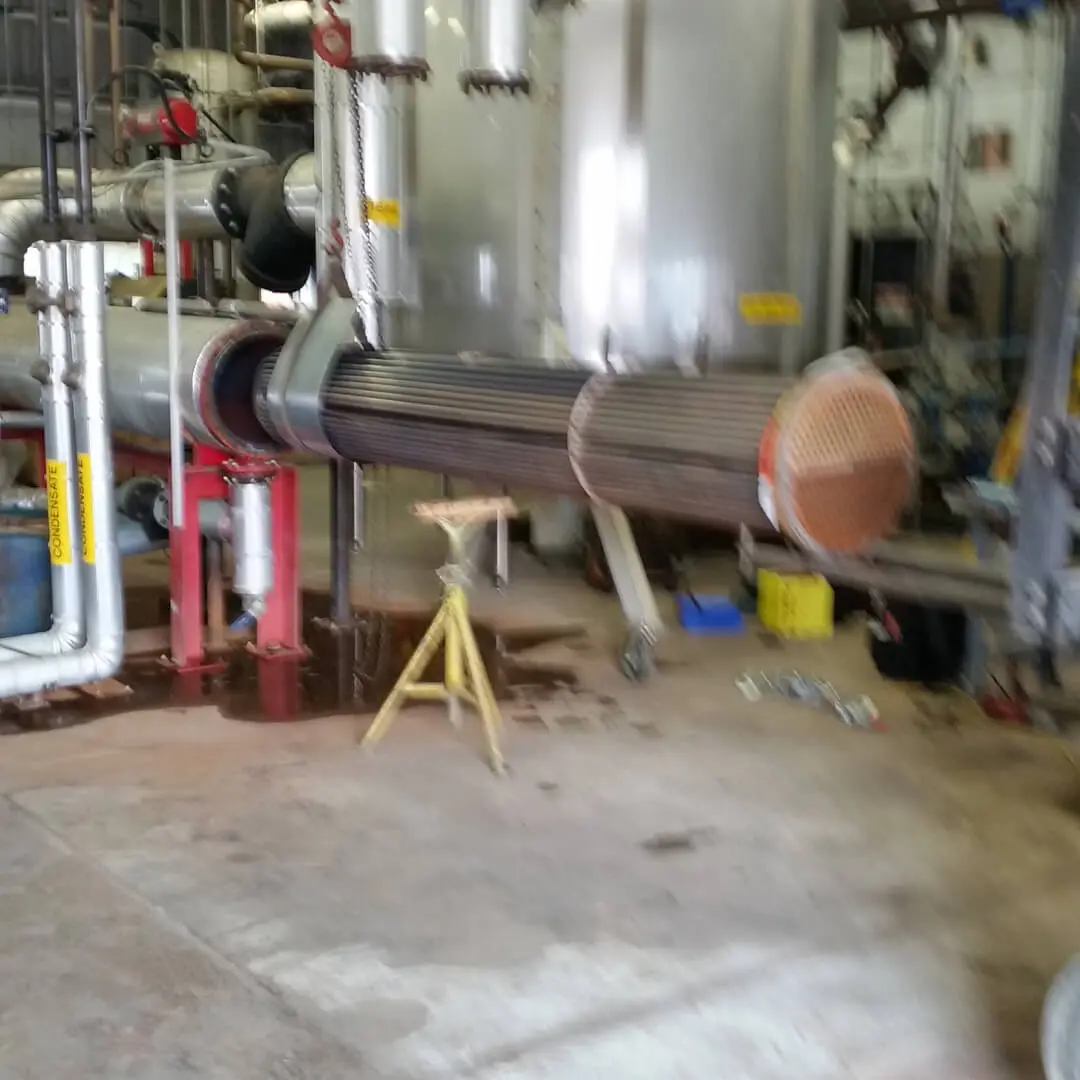 A blurry image of an inside of a factory with metal pipes and tubes all around